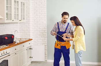 Male-plumber-or-mechanic-talk-speak-with-femal-client-at-home---320X230